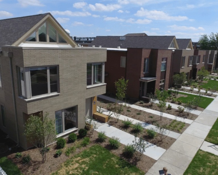 Modern two-story family homes with front lawns and a paved walkway