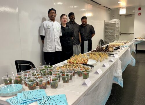 Culinary team at A Safe Haven standing behind a beautifully prepared buffet.