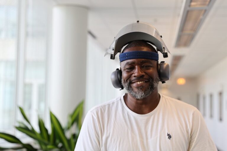Man smiling with protective gear in a training facility