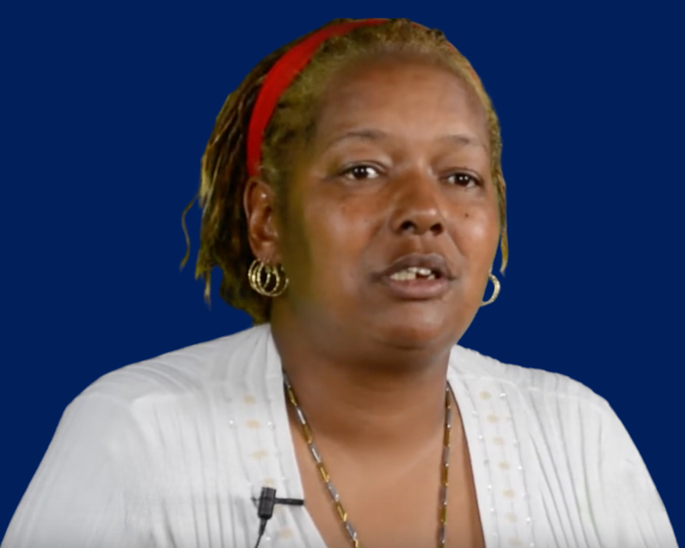 Woman speaking against a blue background