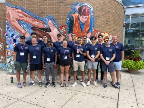 Corporate volunteer team smiling in front of mural at A Safe Haven Foundation.