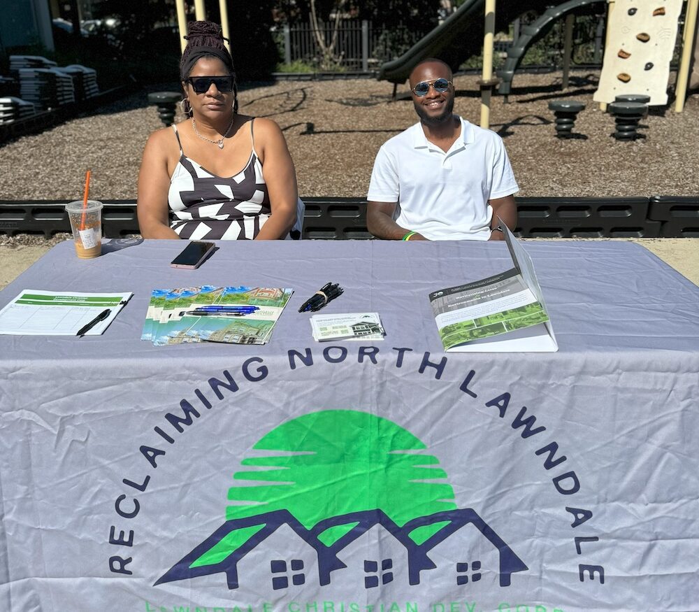 Reclaiming North Lawndale booth with two representatives seated outside.