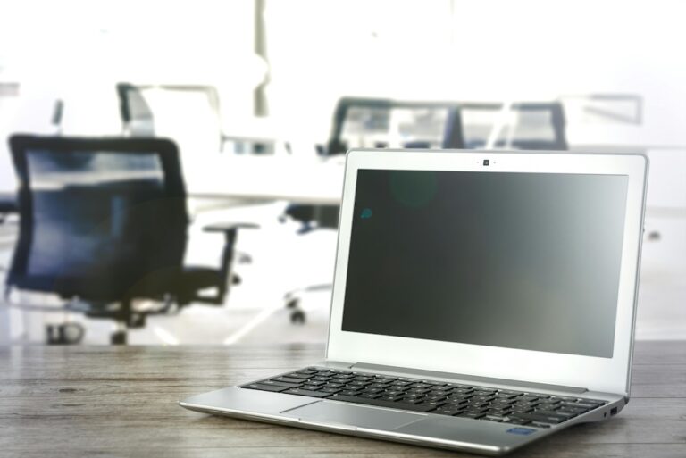 Laptop on desk with blurred office background