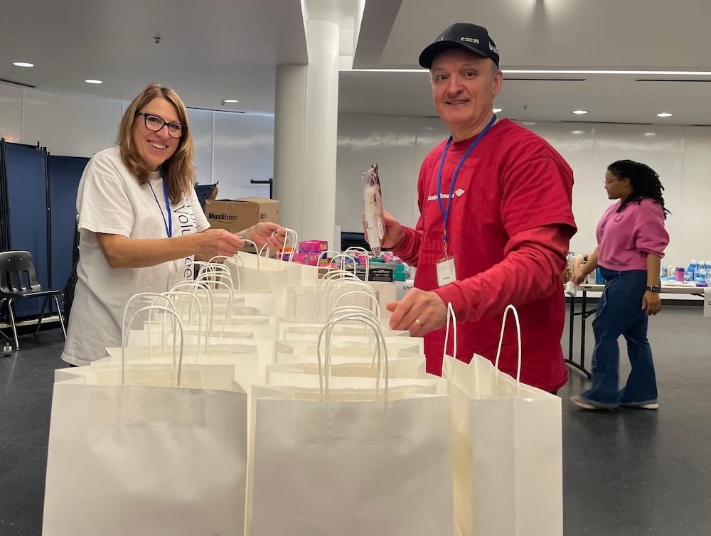 Bank of America volunteers packing donation bags in a room with supplies.