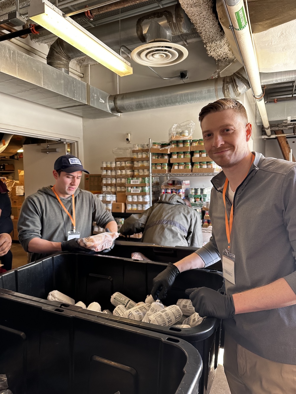 Volunteers sorting food items in a pantry setting.