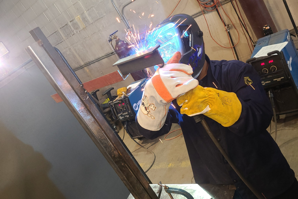 Person welding in a vocational training facility.