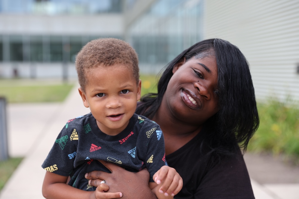 Mother holding her child outside A Safe Haven Foundation's headquarters.