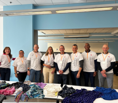 Bank of America volunteers standing behind clothing donation table