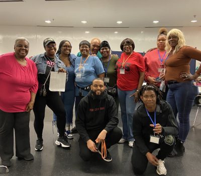 Group of older adults and younger volunteers posing together indoors
