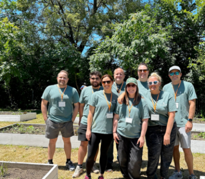 Team of volunteers posing in front of garden beds