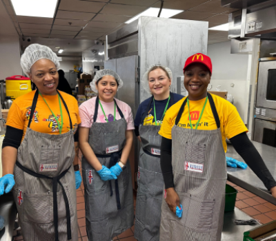 Four McDonald’s volunteers in aprons in kitchen