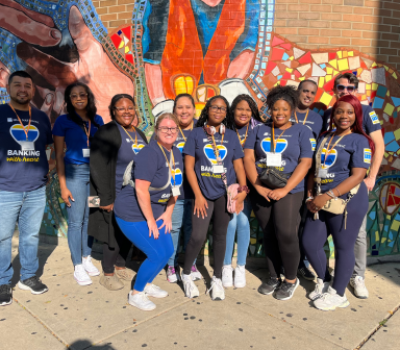 Old National Bank volunteers in front of mosaic mural