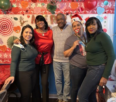 Group of program staff smiling in a community room during the holidays