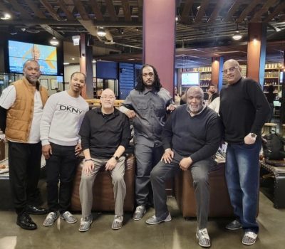 Group of professionally dressed men gathered at a bowling lounge